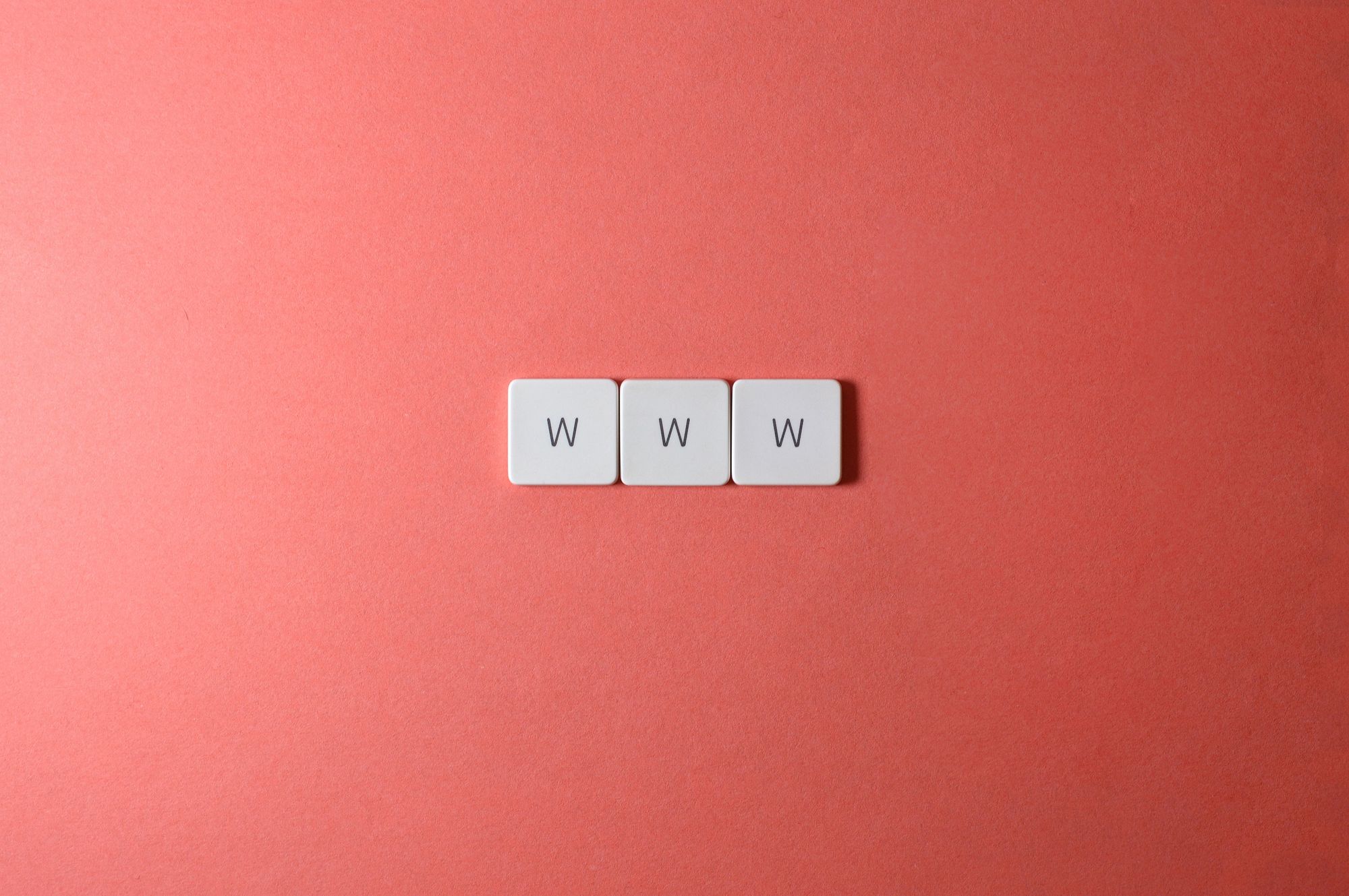 Gros plan sur les touches « WWW » d'un clavier posé sur une surface rouge vif