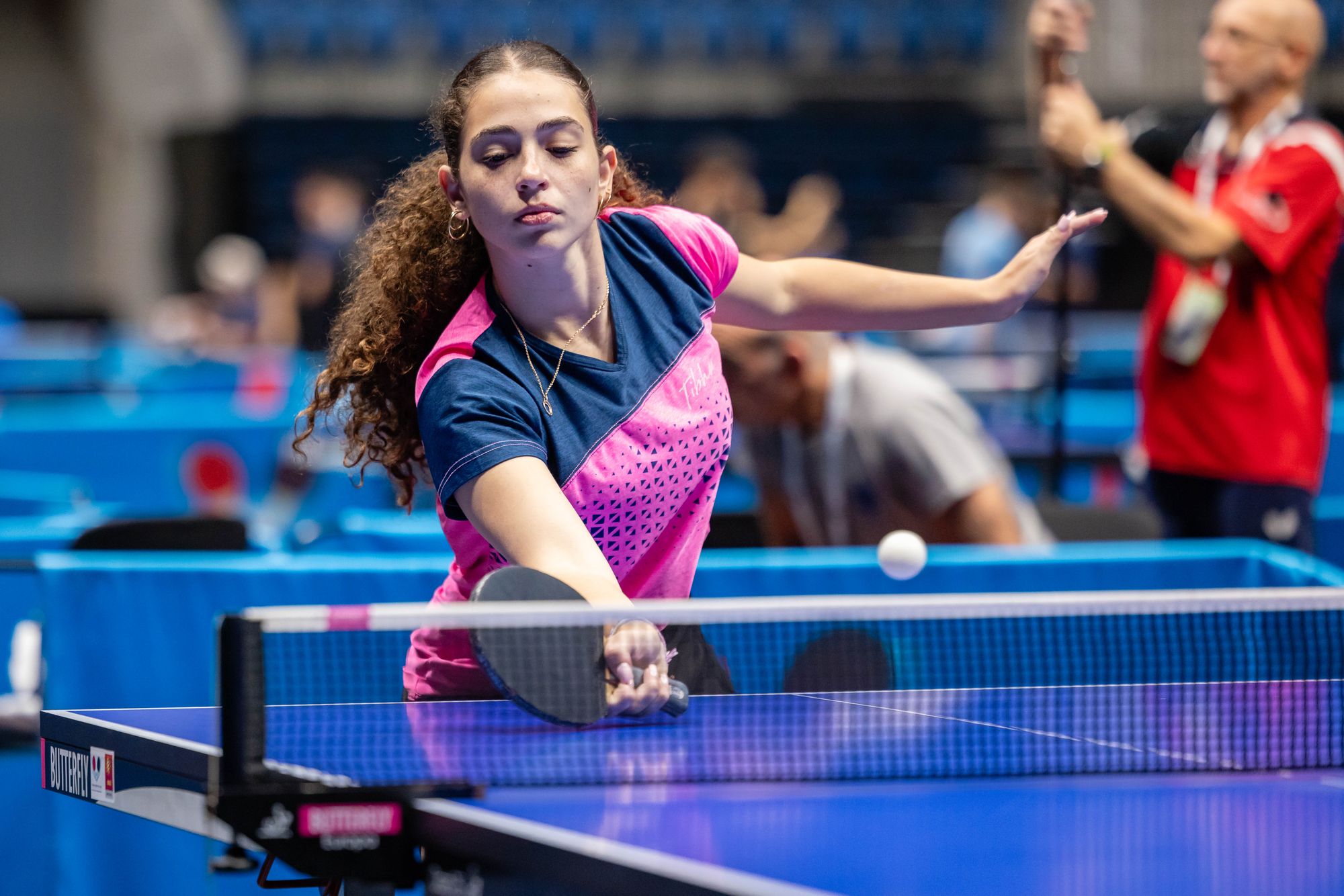 Une athlète intensément concentrée lors d'un match de tennis de table de compétition